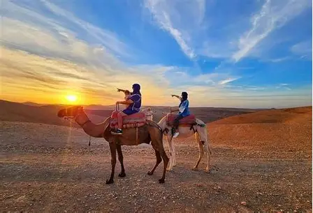 Two riders on camels at sunset