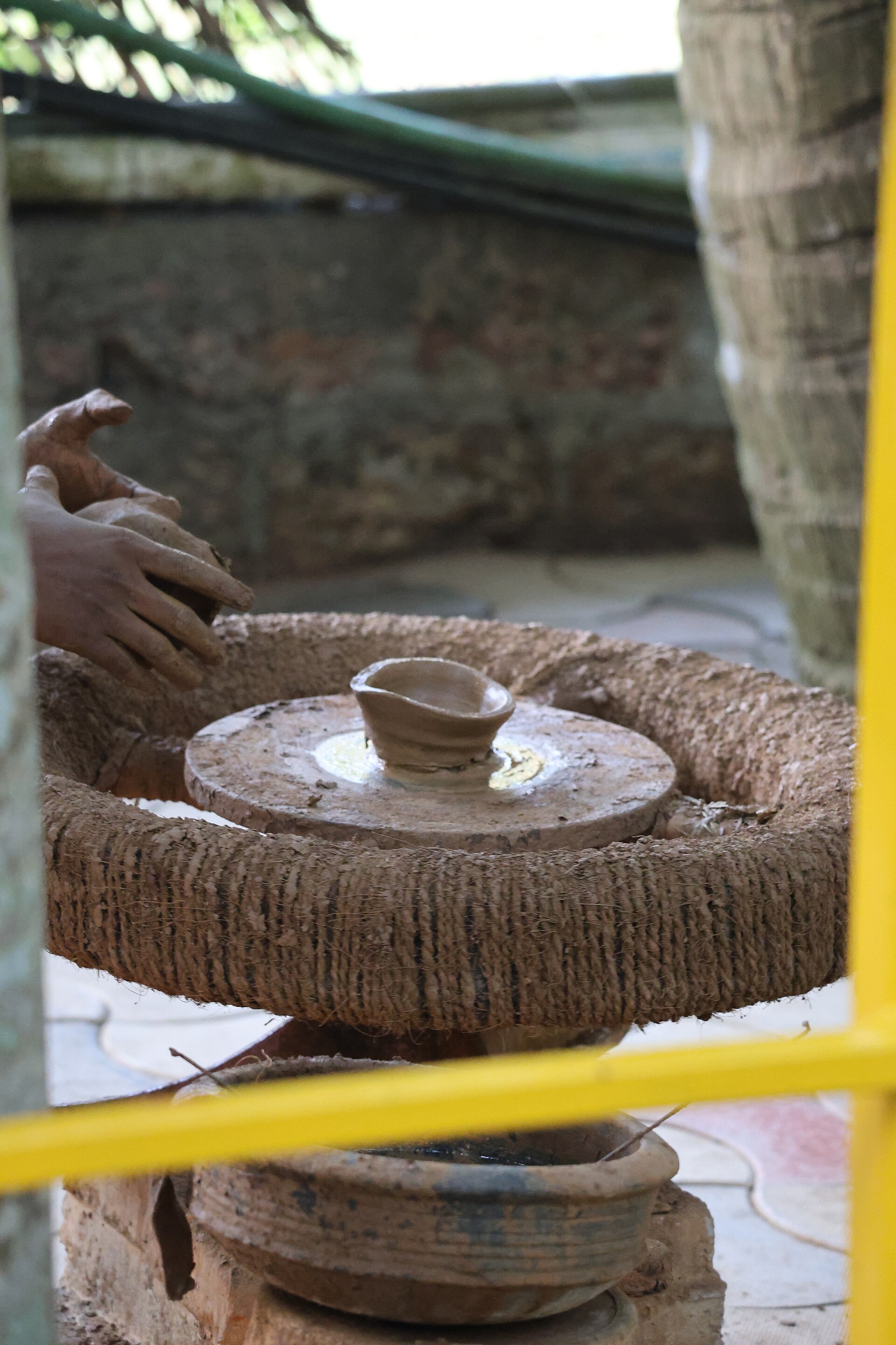 Close-up of hands guiding clay into shape on the wheel